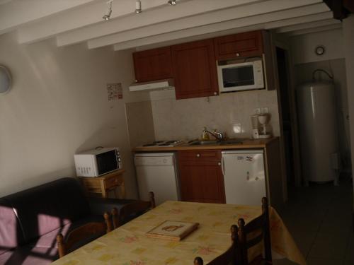 Il comprend une petite cuisine équipée d'une table et d'un réfrigérateur. dans l'établissement Chalet à Luz Saint Sauveur 65, à Luz-Saint-Sauveur