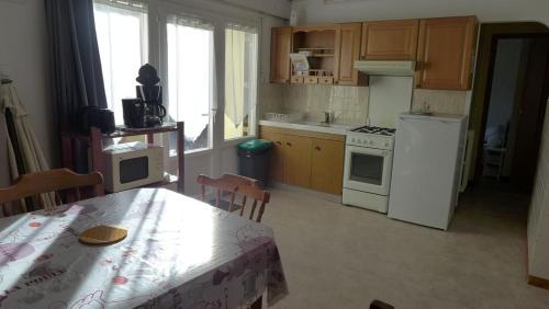 une cuisine avec une table et un réfrigérateur blanc dans l'établissement Les lauriers, à Saint-Palais-sur-Mer