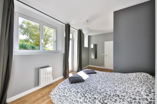 a bedroom with a bed and two windows at Belle vue in Montsoreau