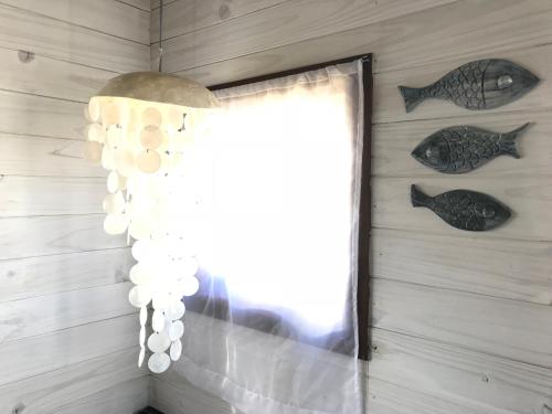 a window in a room with fish on the wall at Casas Sadhana in Punta Del Diablo