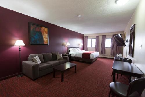 a hotel room with a couch and a bed at Argyll Plaza Hotel in Edmonton