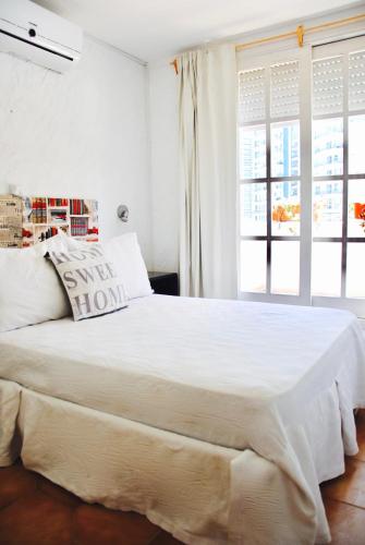 a bedroom with a large white bed with a window at Blu Inn in Punta del Este