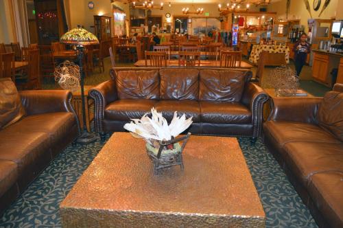 a living room with brown leather couches and a table at Montecito Sequoia Lodge in Sequoia National Park