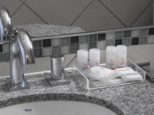 a bathroom counter with a sink with toiletries on it at Fábrica Hotel in Armstrong