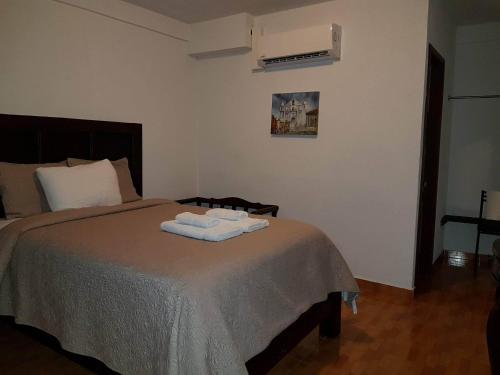a bedroom with a bed with two towels on it at Hotel & Restaurant Fleur de Lis in Concepción de Ataco