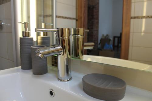a bathroom sink with a faucet and a mirror at Apartamentai Kauno centre in Kaunas