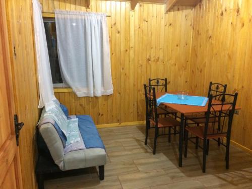 a dining room with a table and chairs and a window at Cabañas El Sol de Dichato in Dichato