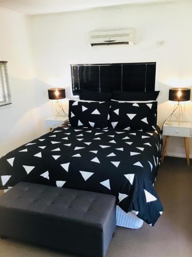 a bedroom with a black and white bed and two lamps at Cottage on Cork Steadman Cottage in Winton