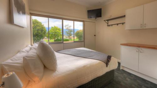 a bedroom with a bed with a large window at Corryong Hotel Motel in Corryong