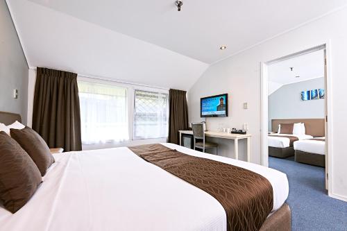 Pokój hotelowy z dużym łóżkiem i biurkiem w obiekcie Mount Richmond Hotel w Auckland