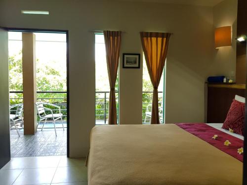 a bedroom with a large bed and a balcony at Sanur Agung Hotel in Sanur