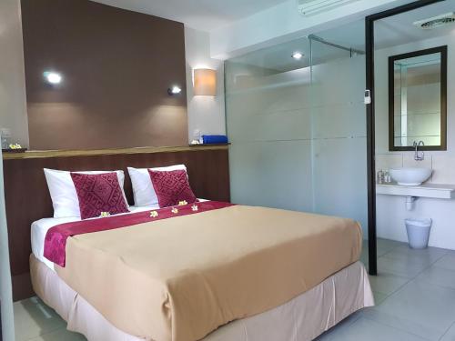 a bedroom with a large bed and a bathroom at Sanur Agung Hotel in Sanur