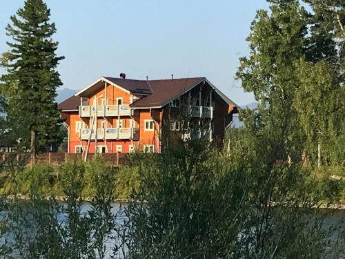 a large house on the side of a river at Usadba Novosnezhka in Novosnezhnaya