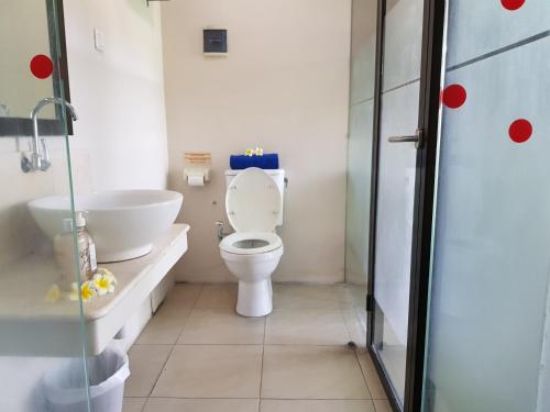 a bathroom with a toilet and a sink at Sanur Agung Hotel in Sanur