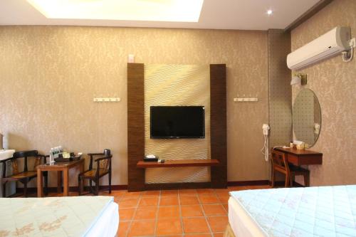 a hotel room with a tv and a bedroom at SEAVIEW-SHOY B&B in Xiaoliuqiu