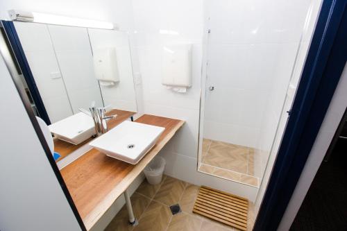 een badkamer met een wastafel en een douche bij Mad Monkey Waterfront in Cairns