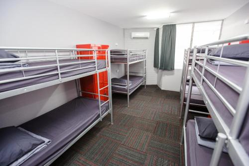 a room with several bunk beds in a dorm room at Mad Monkey Waterfront in Cairns