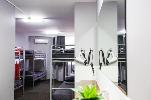 a room with bunk beds and a mirror at Mad Monkey Waterfront in Cairns