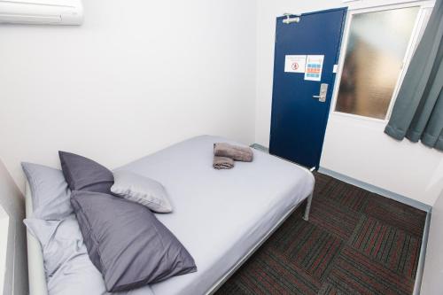 a small room with a bed and two windows at Mad Monkey Waterfront in Cairns