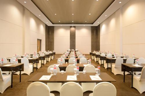 a large banquet hall with tables and white chairs at Swiss-Belinn Luwuk in Luwuk
