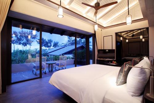 a bedroom with a large bed and a balcony at Baba Beach Club Natai Luxury Pool Villa Hotel by Sri panwa - SHA Plus in Natai Beach