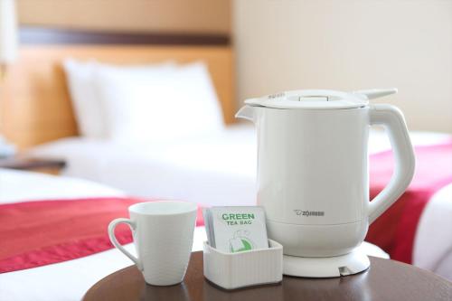 a white blender sitting on a table next to a cup at Hotel Hokke Club Sapporo in Sapporo