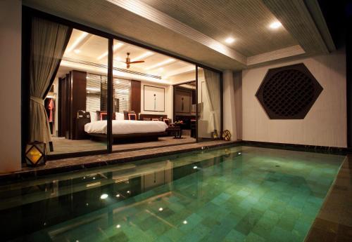 a hotel room with a swimming pool and a bed at Baba Beach Club Natai Luxury Pool Villa Hotel by Sri panwa - SHA Plus in Natai Beach
