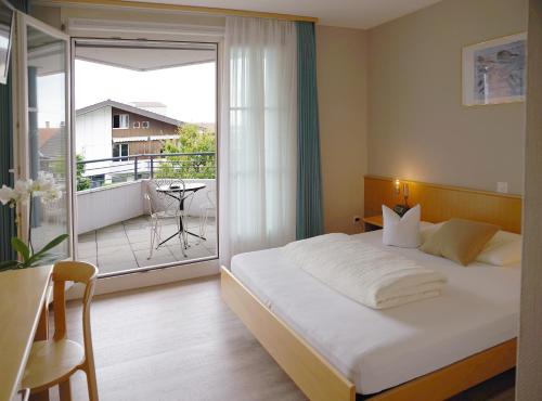 una camera d'albergo con un letto e un balcone di Hotel Garni Arnegg ad Arnegg