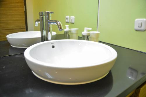 a white sink in a bathroom with a mirror at Treehouse Suites - Boutique Serviced Apartment in Jakarta