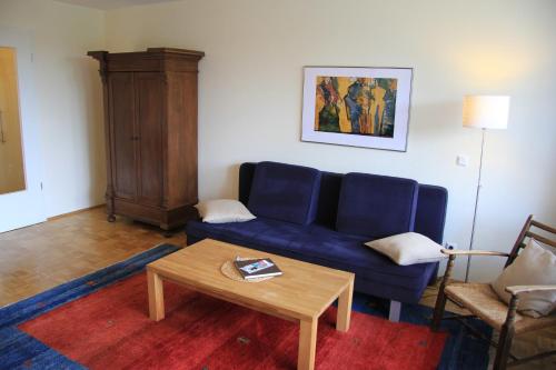 a living room with a blue couch and a coffee table at Ferienwohnungen Familie Böckmann in Berlin