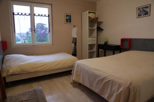 a bedroom with two beds and a window at Hotel Restaurant De La Roche in Les Sauvages