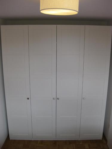 a white closet with white cabinets in a room at Ferienwohnungen Familie Böckmann in Berlin