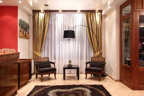 a living room with two chairs and a table and a window at Boutique Hotel Parnassia in Arachova