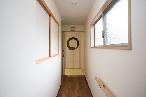 a hallway with a door and two windows at Guesthouse Kyoto Arashiyama in Kyoto