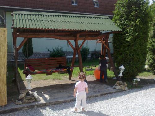 a little girl standing in front of a gazebo at Táltos Vendégház in Szilvásvárad