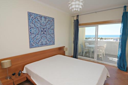 ラゴスにあるVue panoramique sur mer Condominio Do mar Lagosのベッドルーム1室(ベッド1台、景色を望む窓付)