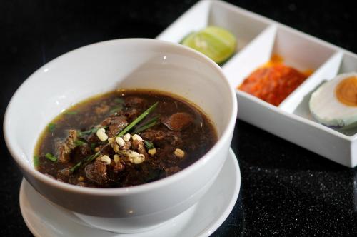 a bowl of soup on a plate on a table at Swiss-Belinn Airport Surabaya in Sidoarjo