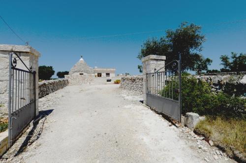 a gate to a house with a building in the background at Agriturismo con Trullo in Alberobello