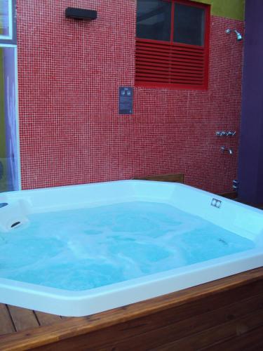 a bath tub with blue water in a bathroom at Infinito Hotel in Buenos Aires