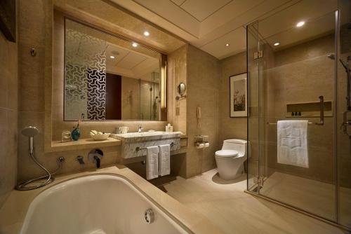 a bathroom with a tub and a sink and a toilet at Shangri-La Tangshan in Tangshan