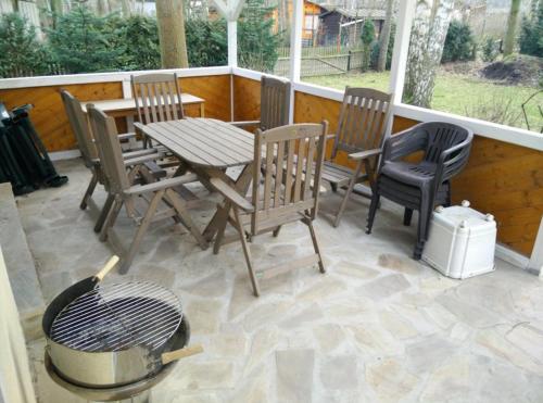 a patio with a table and chairs and a grill at Gemutlicher Ferienbungalow am Felsensee bei Pretzien in Pretzien
