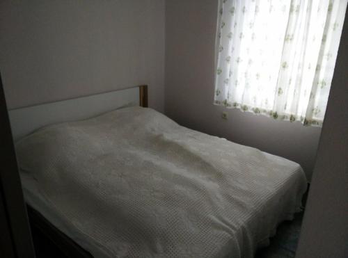 a white bed in a bedroom with a window at Gemutlicher Ferienbungalow am Felsensee bei Pretzien in Pretzien