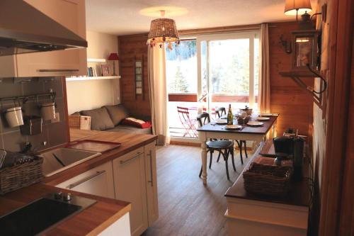 a kitchen with a table and a dining room at Appartements Immeuble Zodiaque in Le Corbier