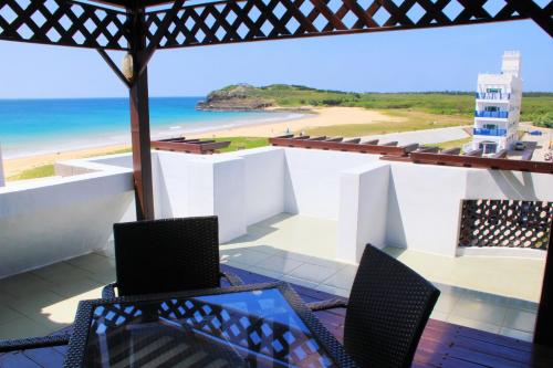 a balcony with chairs and a view of the beach at Beachcastle & Sea View Villa in Magong