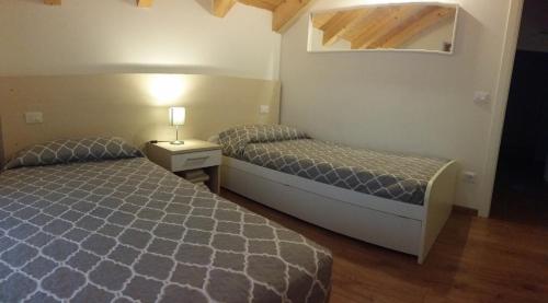 ein Schlafzimmer mit zwei Betten und einem Tisch mit Lampe in der Unterkunft B&B Tomaselli in Striegen