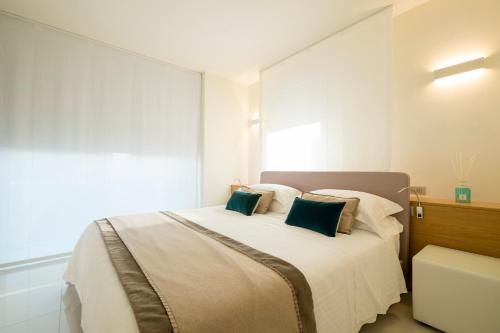 a bedroom with a large white bed with green pillows at Metropol Ceccarini Suite - Luxury apartments in Riccione