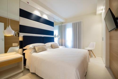a bedroom with a large bed with a blue and white wall at Metropol Ceccarini Suite - Luxury apartments in Riccione