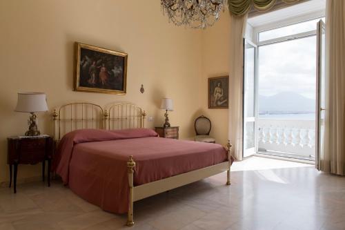 a bedroom with a bed and a large window at Casa Bellevue in Naples