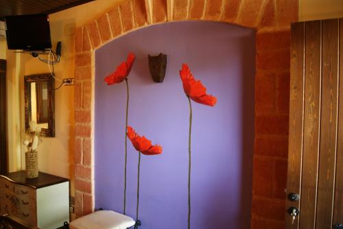 three red poppies on the wall of a room at Rincon Del Cierzo in Lécera