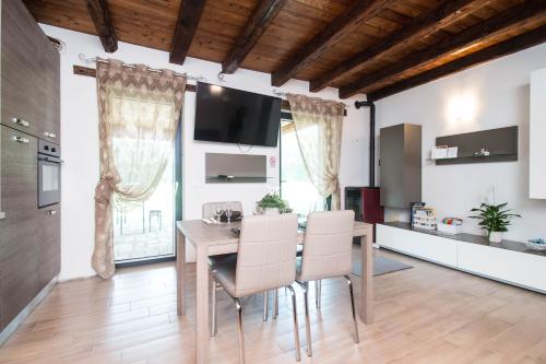 a kitchen and dining room with a table and chairs at Villa Broglia House in Verona